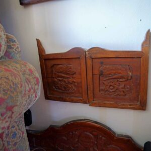 Pair of vintage Chinese hand-carved wooden wall panels featuring detailed floral and bird relief designs.